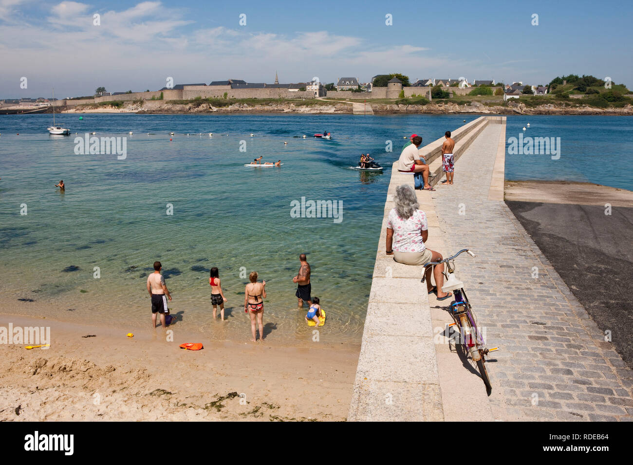 Gavres (Bretagne, nord-ouest de la France) : les vacanciers sur la plage et la digue du port de tombes et la vue de la citadelle de Port-Louis dans le Banque D'Images