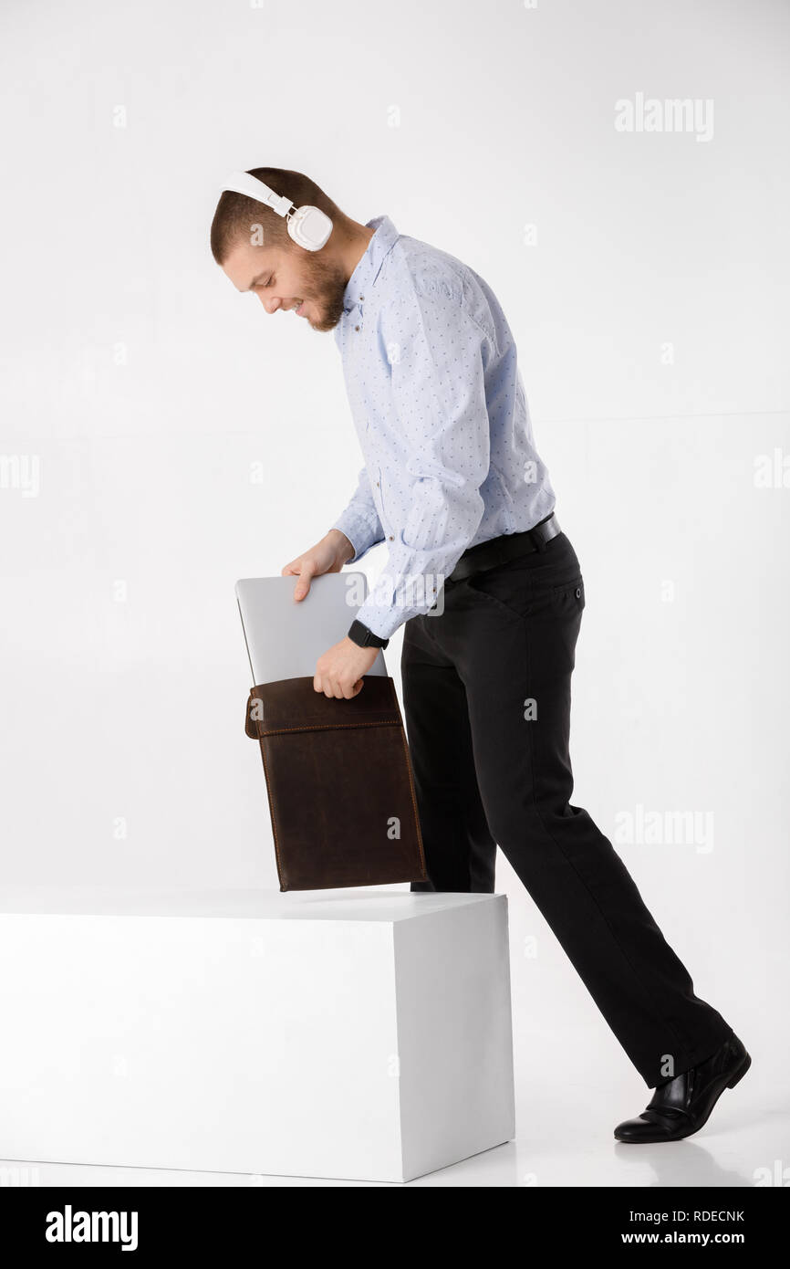 Businessman in headphones met dans le couvercle pour ordinateur portable Banque D'Images