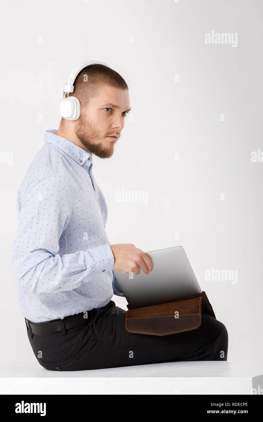 Businessman in headphones met dans le couvercle pour ordinateur portable Banque D'Images