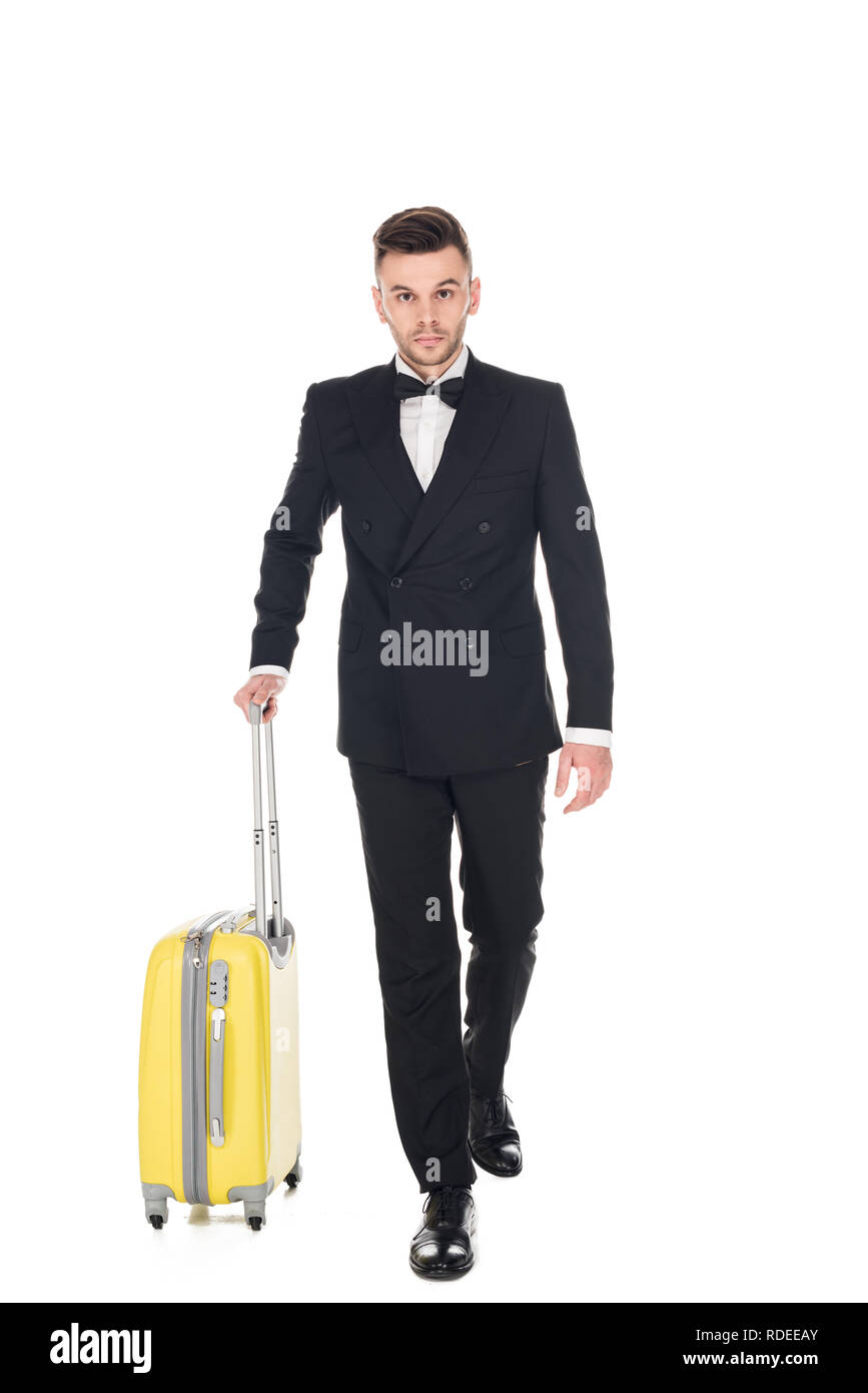 Beau séjour touristique en tuxedo noir marcher avec suitcase isolated on white Banque D'Images