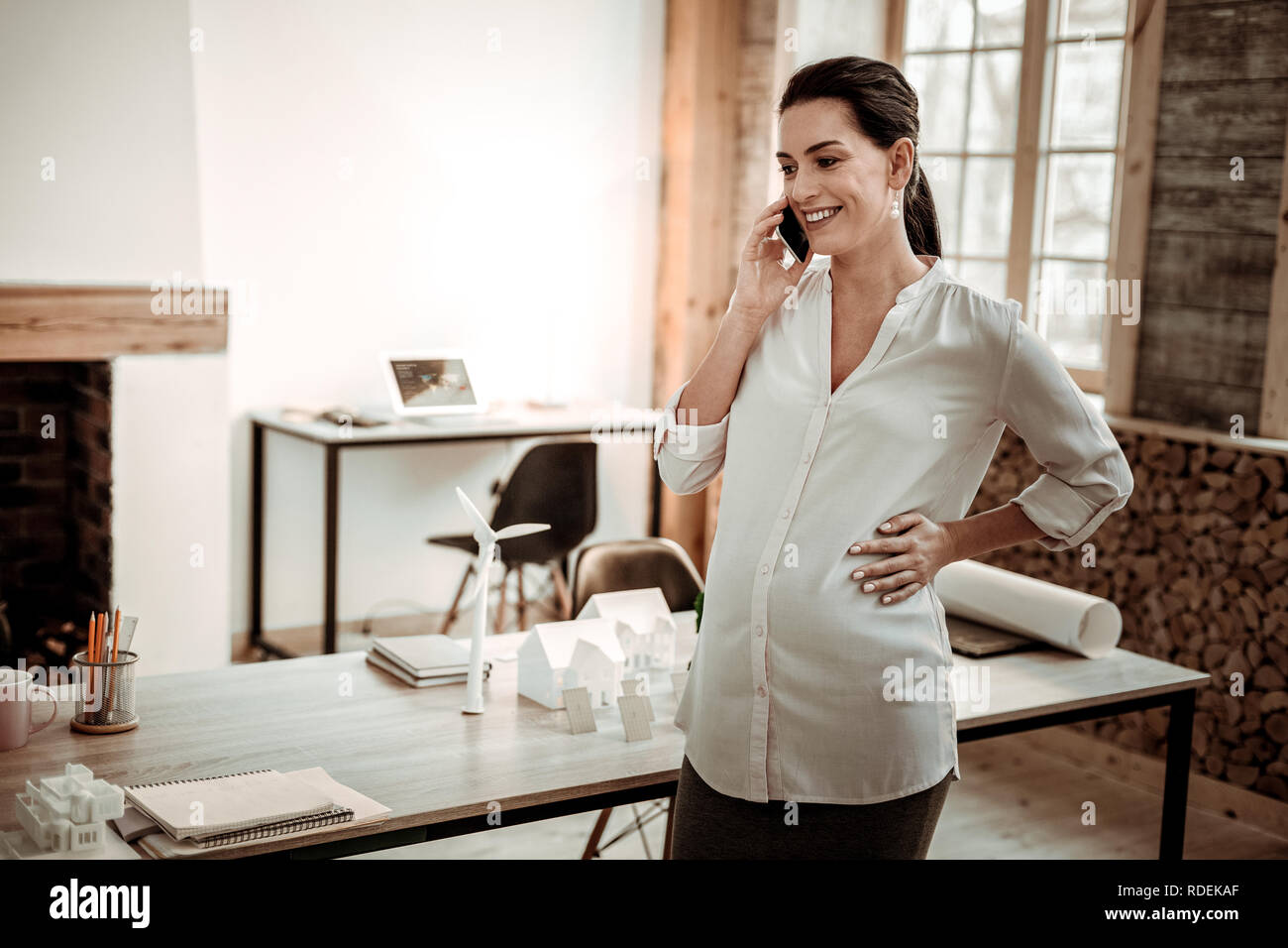 Heureuse femme enceinte répondant à l'appel téléphonique Banque D'Images