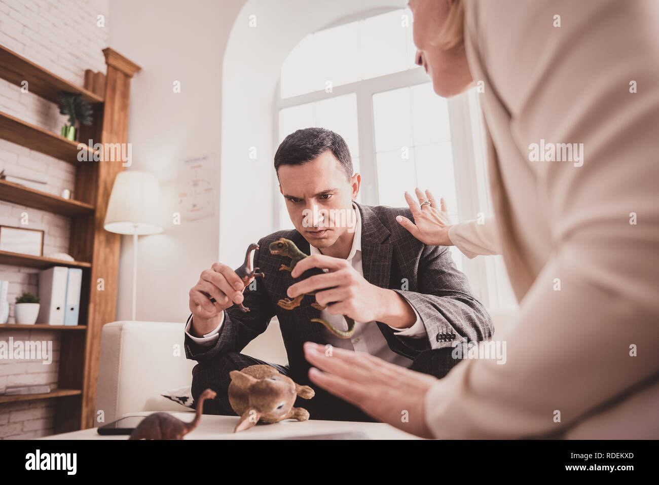 Jeune homme en colère à regarder ses jouets Banque D'Images