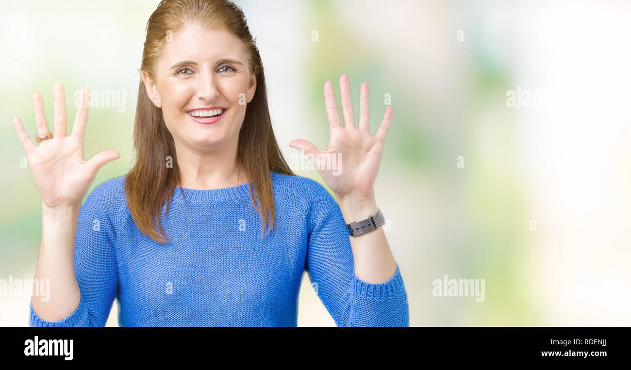 Beau moyen age mature woman wearing winter sweater sur fond isolés montrant et pointant vers le haut avec les doigts le numéro dix en souriant sécuri Banque D'Images