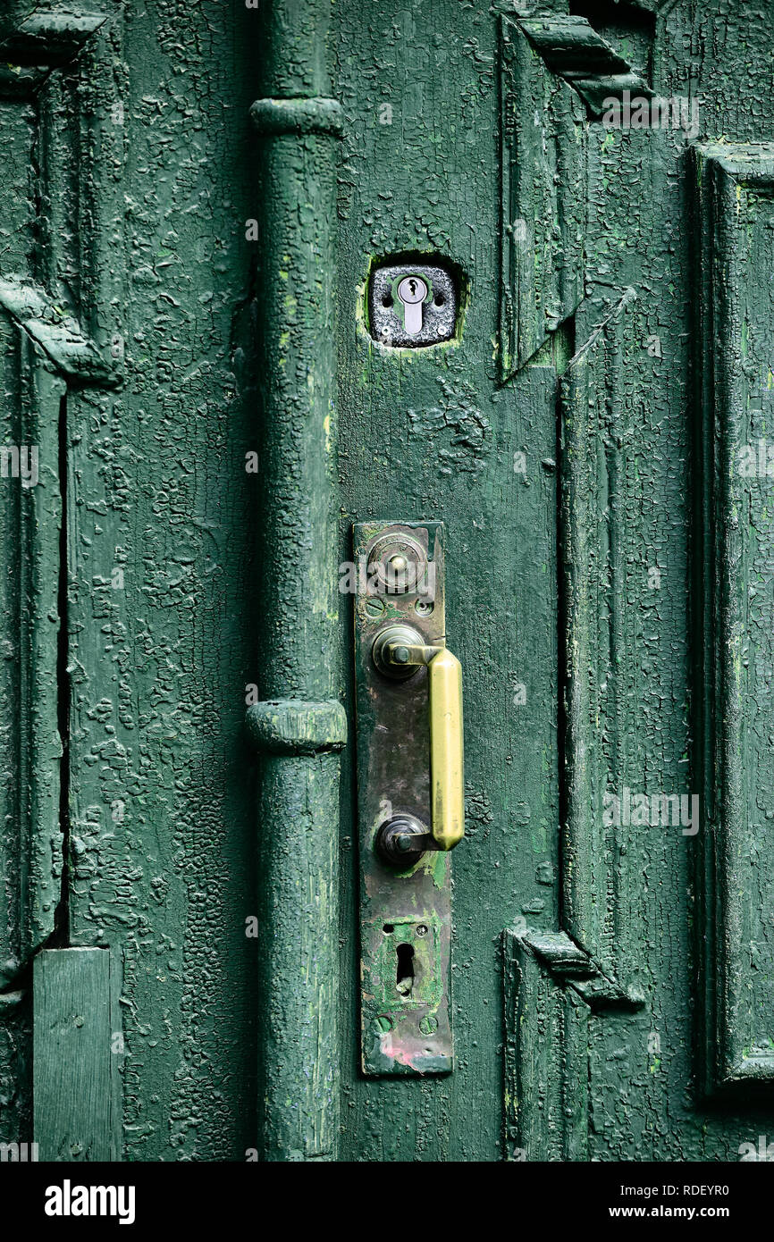 Vieille porte en bois sculpté peint avec la peinture à l'huile vert bronze  avec poignée et serrure d'acier, élément de design de la rue typique de la  vieille ville européenne Photo Stock -