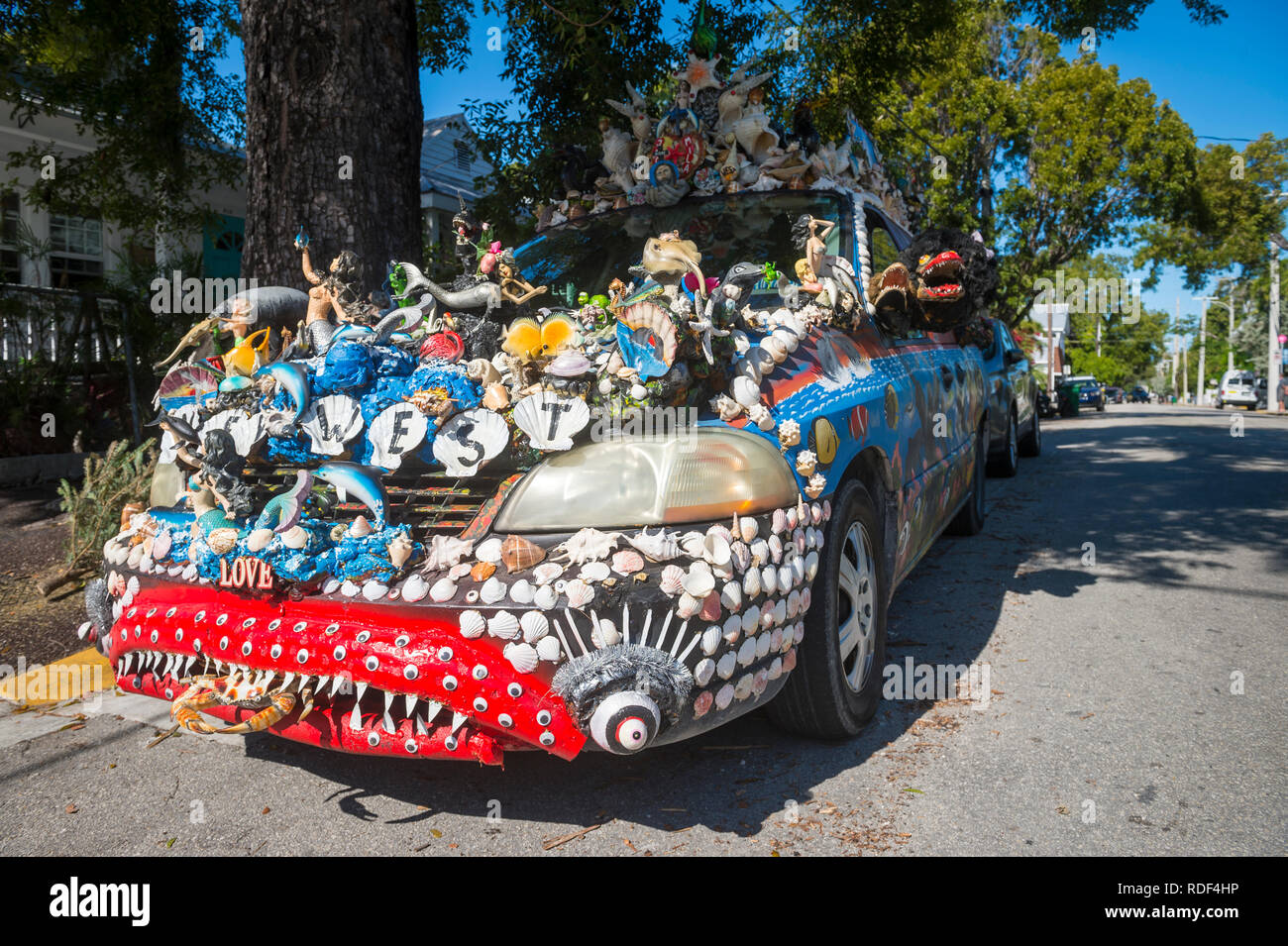 KEY WEST, Floride, USA - Le 14 janvier 2019 : une voiture décorée avec un mélange unique d'obus et de figurines est stationné sur une rue résidentielle calme. Banque D'Images