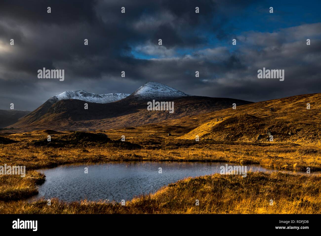 Petit lac au premier plan des pics de montagne couverte de neige de Meall a'Bhüiridh Leathad et Clach dans l'arrière-plan et spectaculaire Banque D'Images