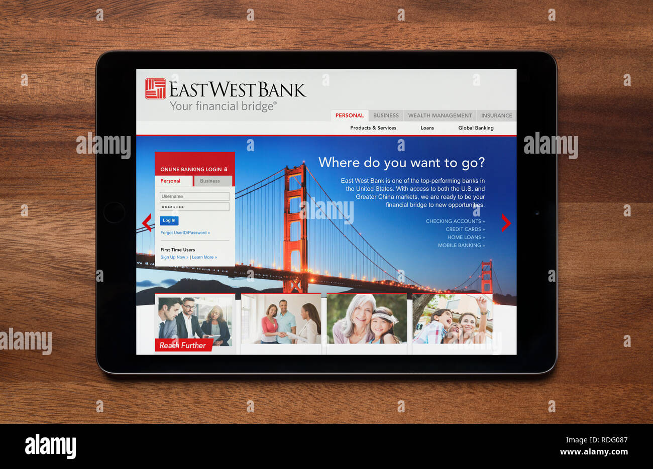 Le site d'East West Bank est vu sur un iPad tablet, qui repose sur une table en bois (usage éditorial uniquement). Banque D'Images