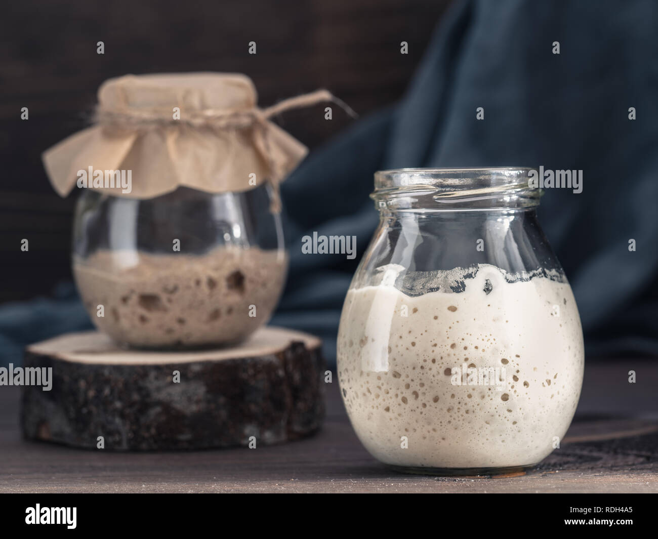 Le blé et le seigle Active levain dans un bocal en verre sur fond de bois brun. Démarreur pour pain au levain. La tonalité de l'image. Copier l'espace. Banque D'Images