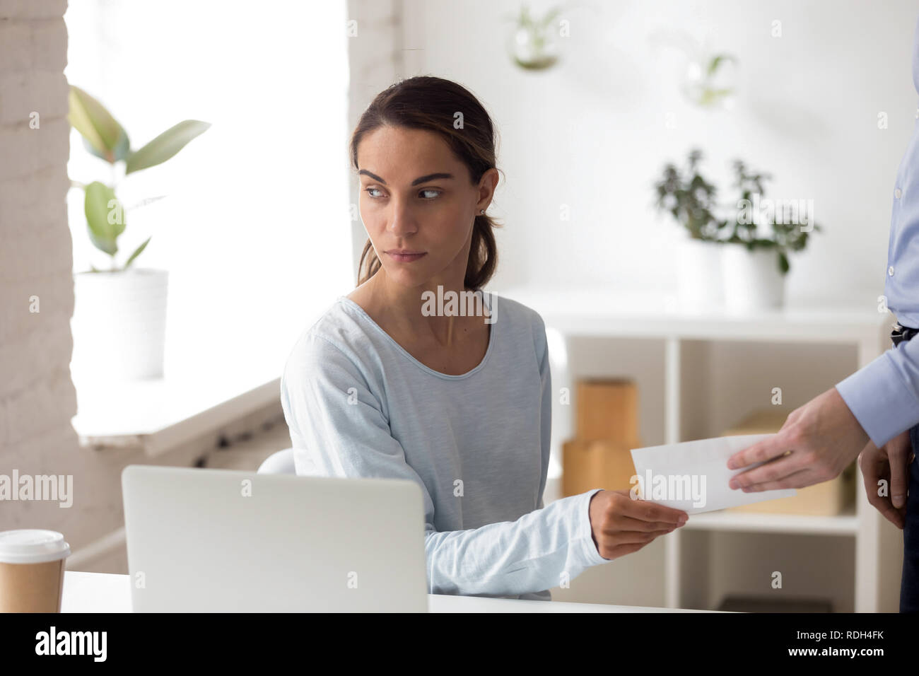 Worried woman en tenant l'enveloppe avec pot-de-personne à workplac Banque D'Images