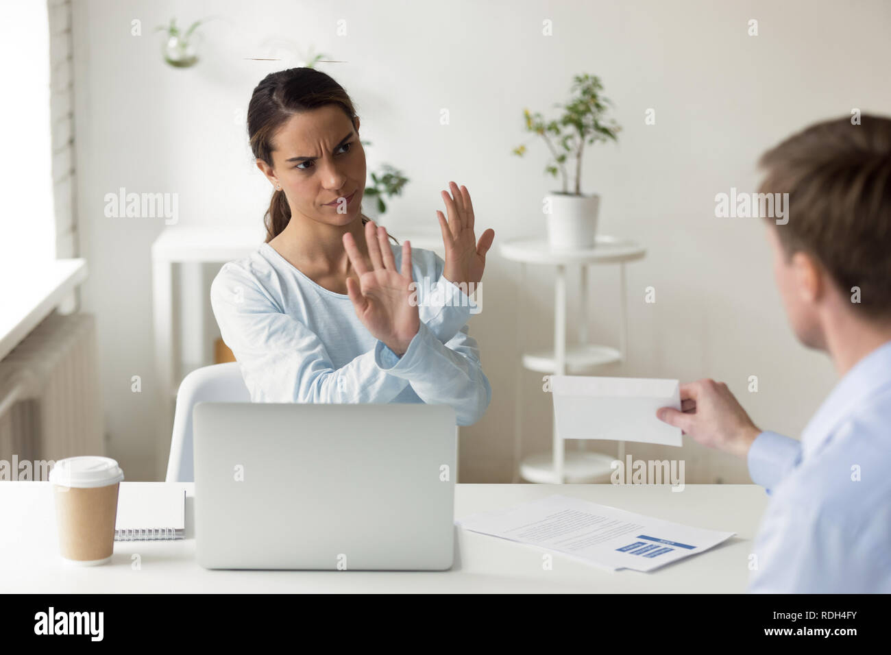 Femme d'Indignés refusant enveloppe avec pot-au lieu de travail Banque D'Images