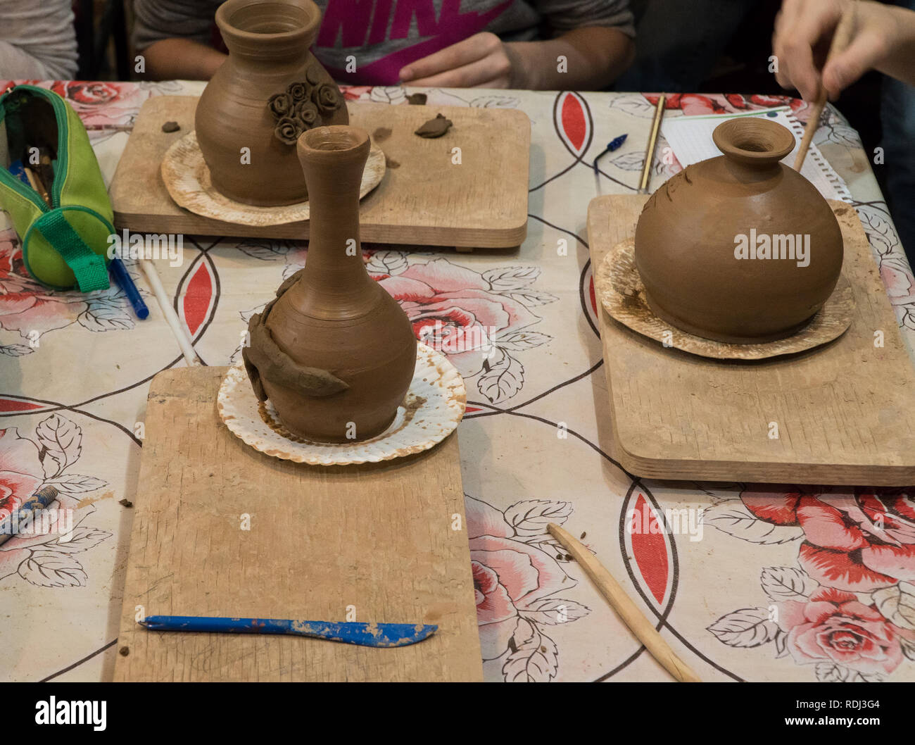 Enfant dans le processus de décoration du pot en argile de poterie pour enfants. Banque D'Images