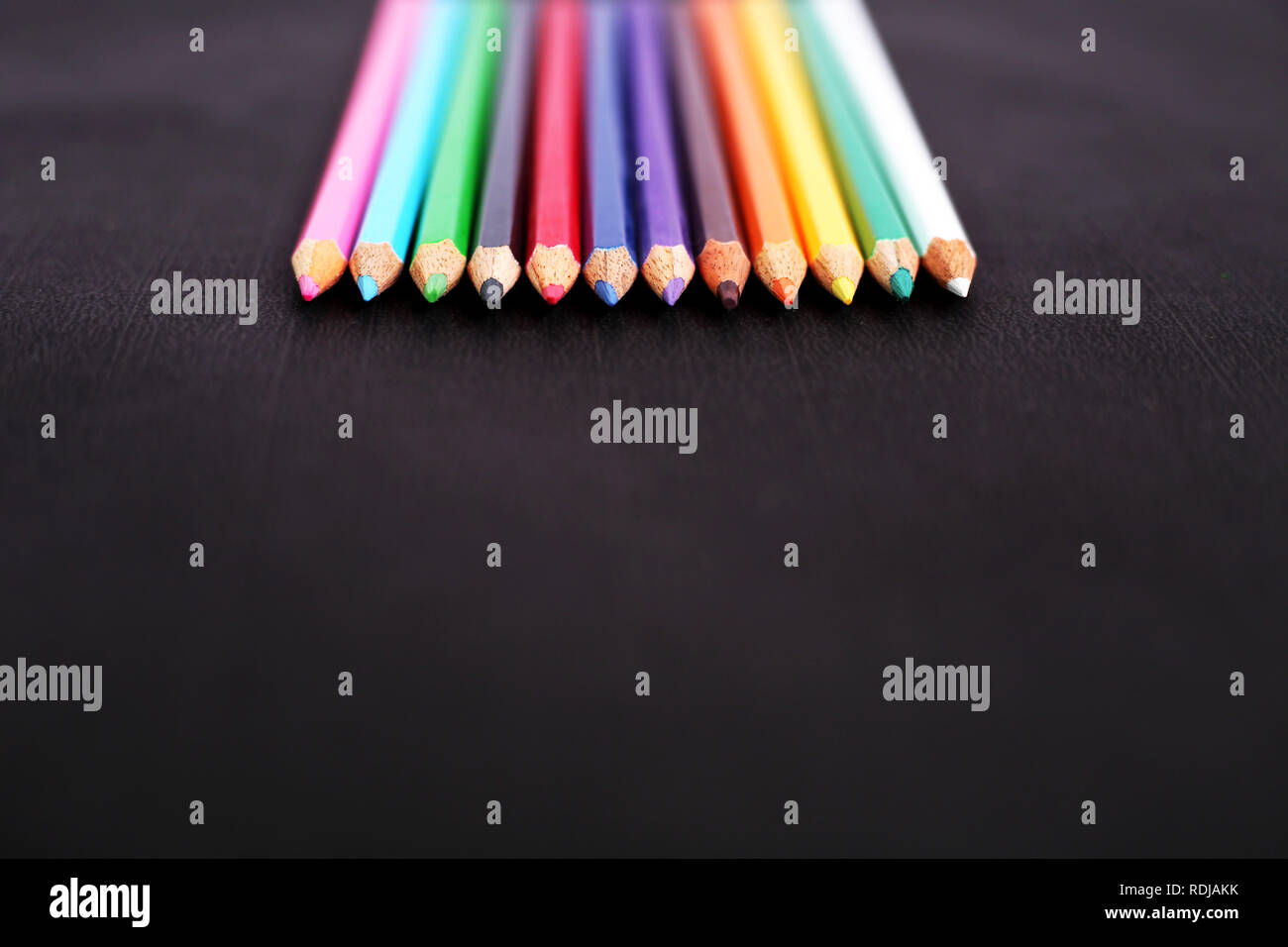 Photo de crayons de couleur en bois. Isolé sur le fond noir. Banque D'Images