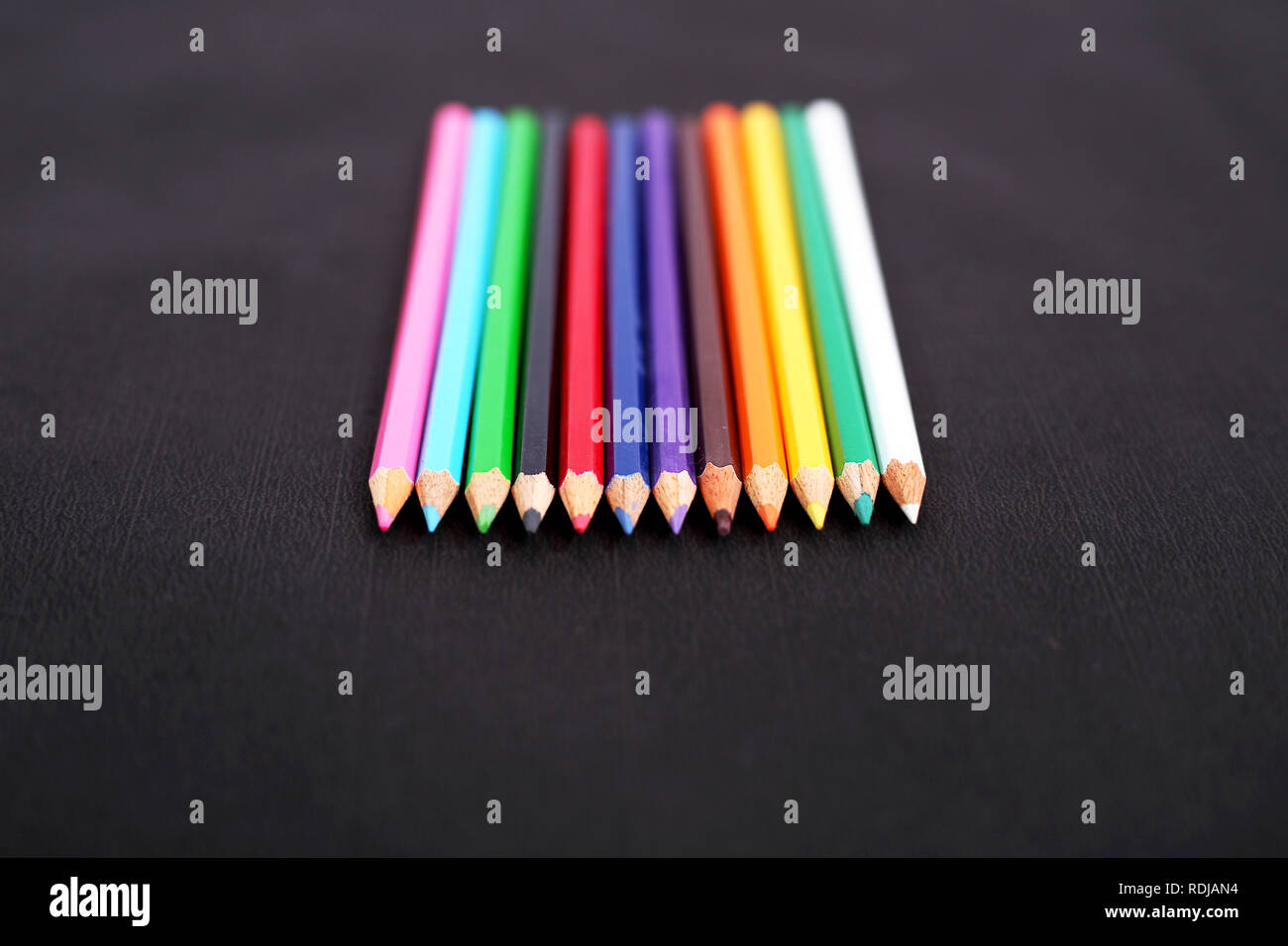 Photo de crayons de couleur en bois. Isolé sur le fond noir. Banque D'Images
