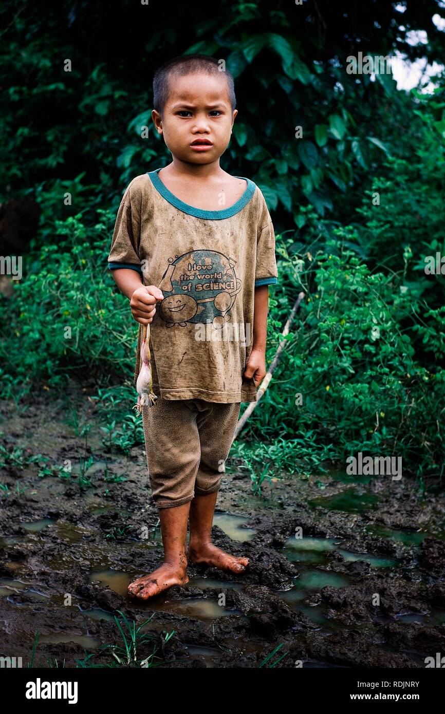 Luang Namta / Laos - 06 juil 2011 : petit enfant tenant une grenouille dans la campagne forêt tropicale de l'Asie du Sud Est Banque D'Images