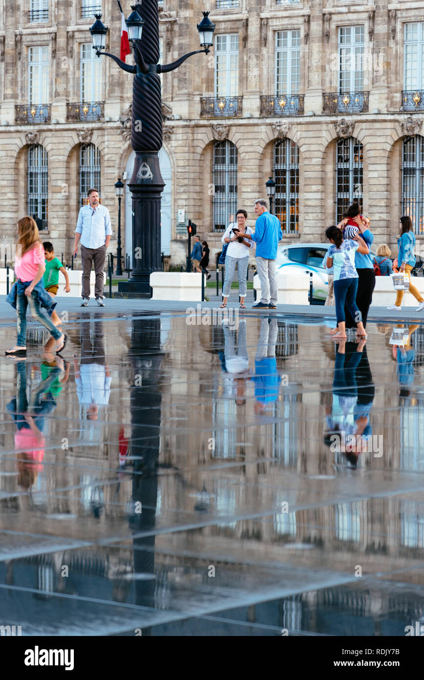 Bordeaux, France - Juillet 22, 2018 : les personnes bénéficiant de l'eau sur le miroir. Situé en face de la Place de la Bourse, cette piscine alterne un effet miroir un Banque D'Images