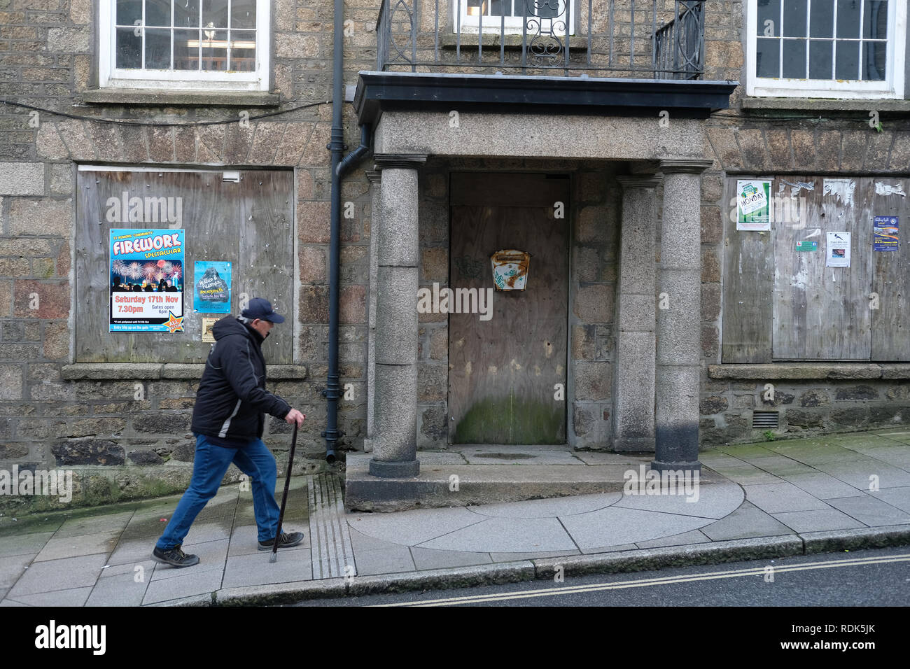 Un homme qui passe devant un immeuble fermé à Helston, dans les Cornouailles Banque D'Images