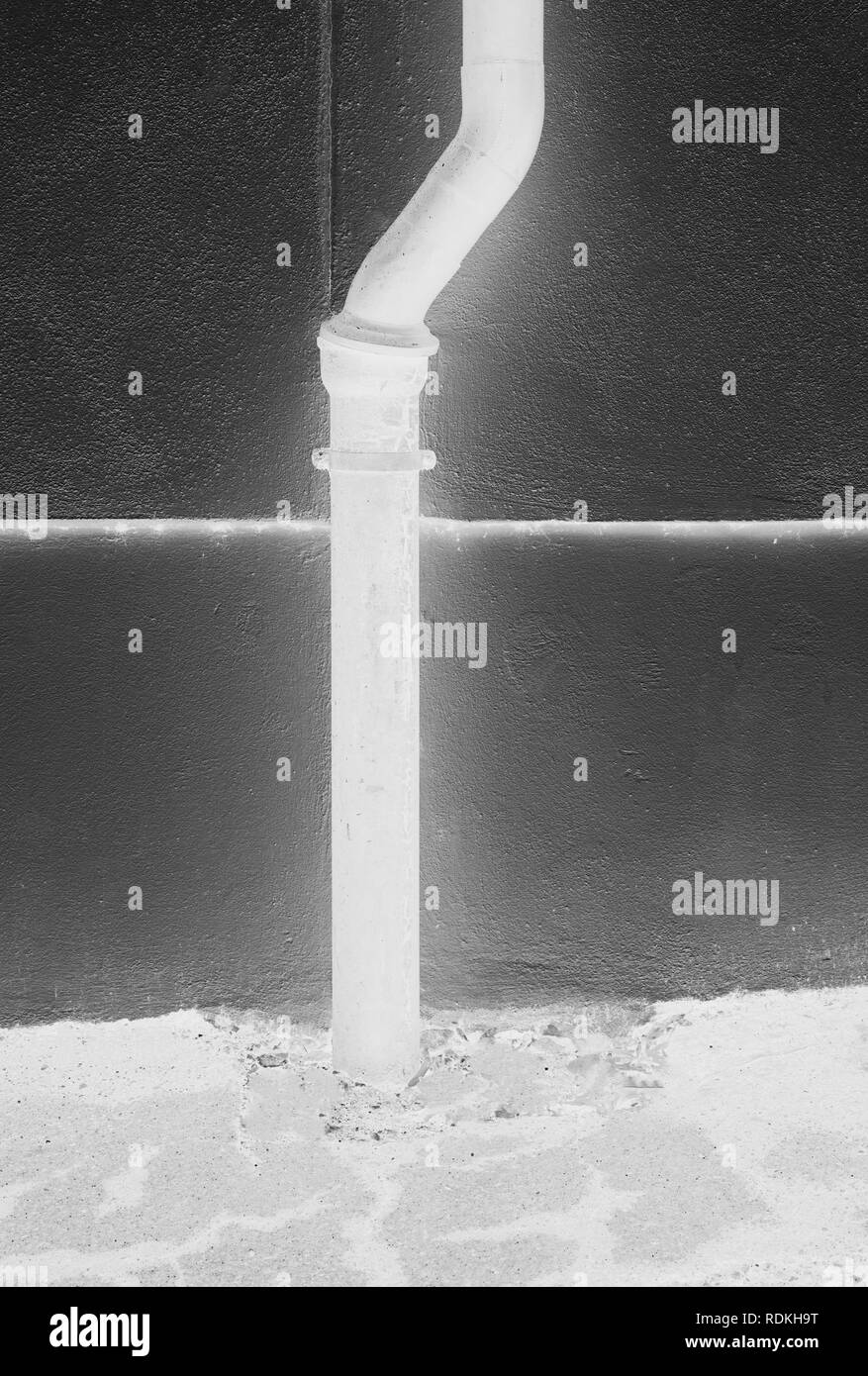 Gouttière blanche surréaliste devant un mur noir - couleurs inversées donner un conte comme l'effet de cette image Banque D'Images