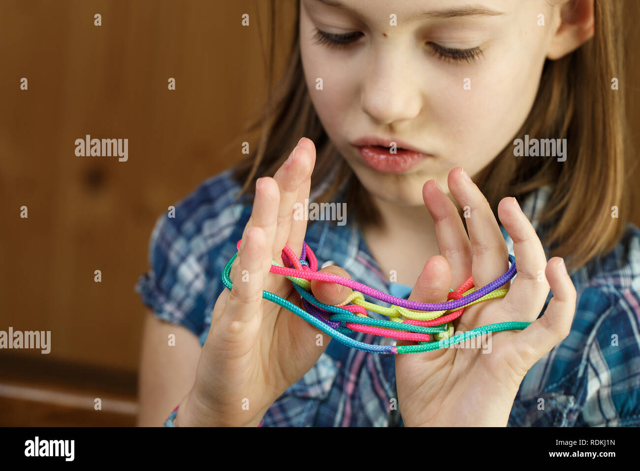 Enfant jouant old-school, classique jeu de chaîne et didactique jouet avec ses doigts, la création de formes, de développer ses capacités motrices. IQ, l'éducation, l'intellig Banque D'Images