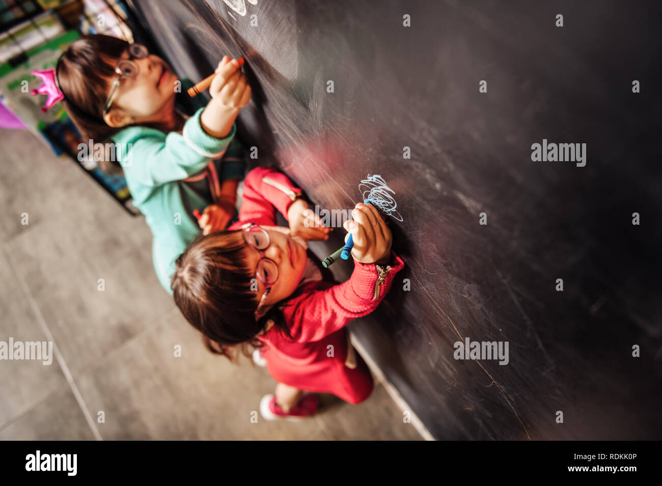 Vue supérieure de deux enfants portant des lunettes de soleil s'appuyant sur tableau noir Banque D'Images