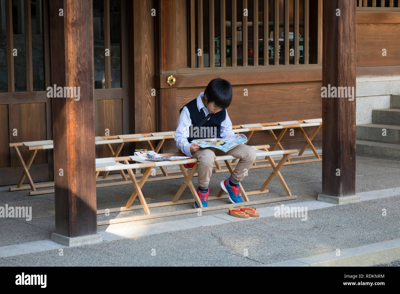 Kumamoto, Japon - 11 novembre 2018 : petit garçon est en train de lire un livre en face de Izumi culte dans Jōjuen, Suizenji Jardin Suizenji Banque D'Images