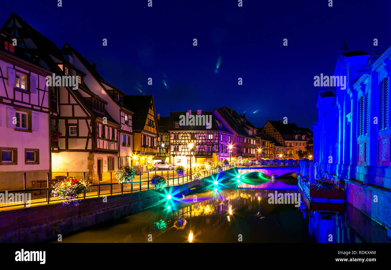 Vieilles maisons colorées illuminée, petite rivière, de l'eau Reflet la nuit au printemps, Colmar, France. Banque D'Images