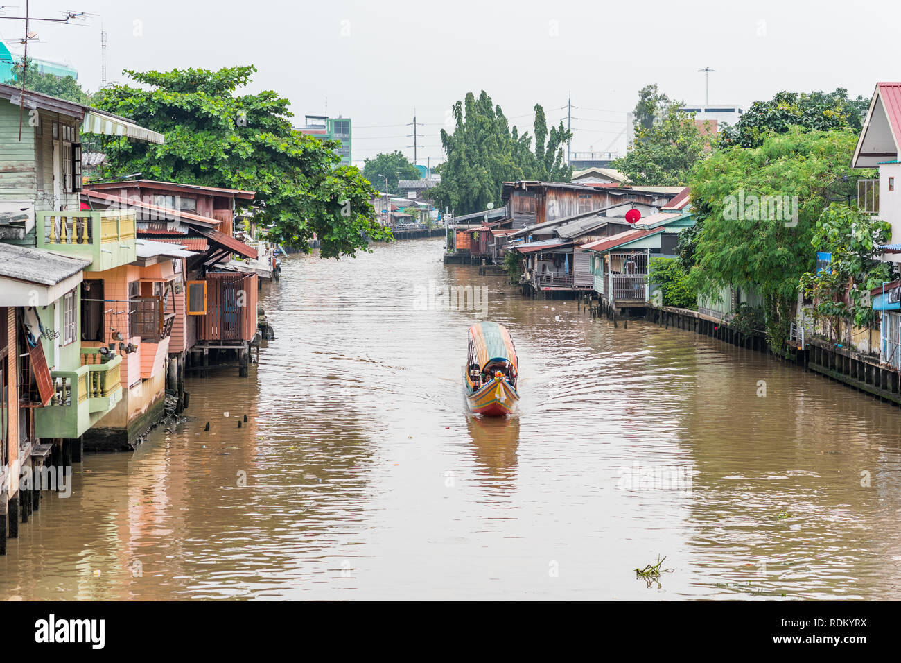 Bangkok, Thaïlande - 8 septembre 2018 : Khlong Mon, l'un des canaux de Thonburi, avec des maisons le long de lui et un bateau de tourisme. Banque D'Images