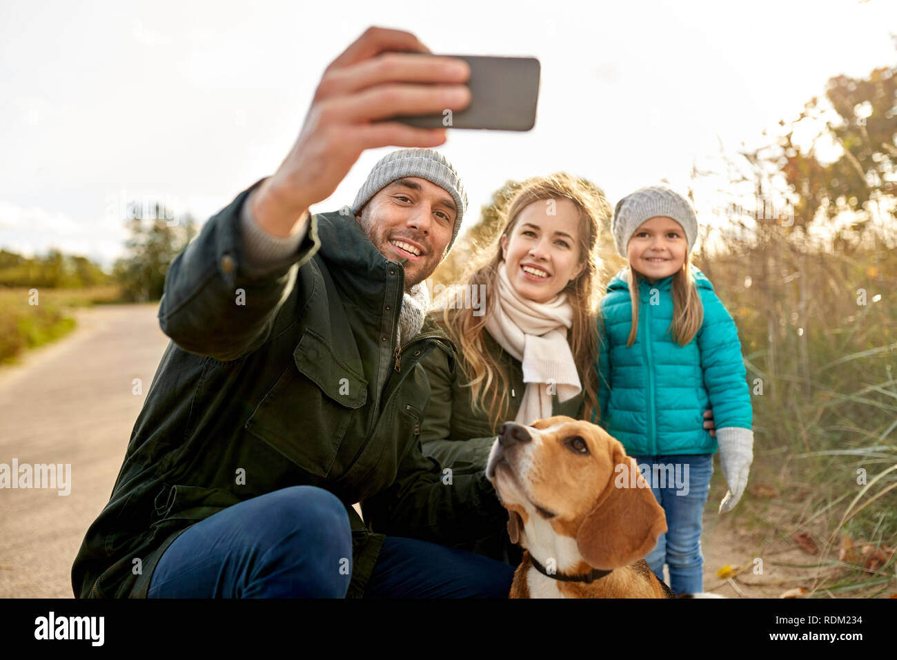 Famille heureuse avec chien prenant en automne selfies Banque D'Images