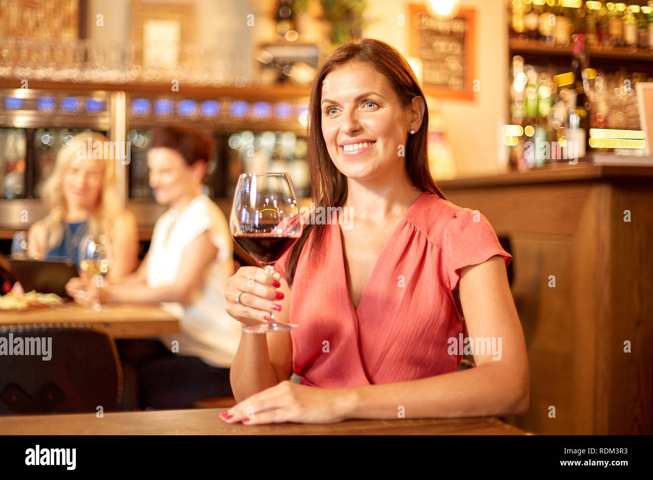 Happy woman drinking red wine au bar ou restaurant Banque D'Images