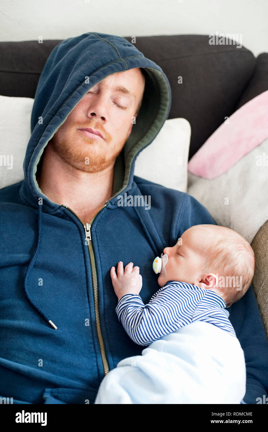 Père de dormir sur un canapé avec son bébé Banque D'Images