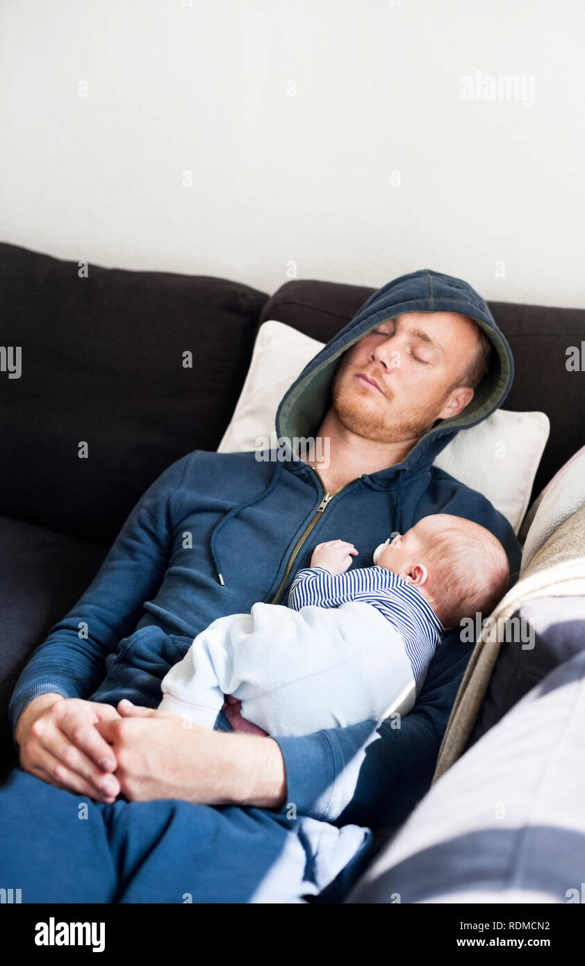 Père de dormir sur un canapé avec son bébé Banque D'Images