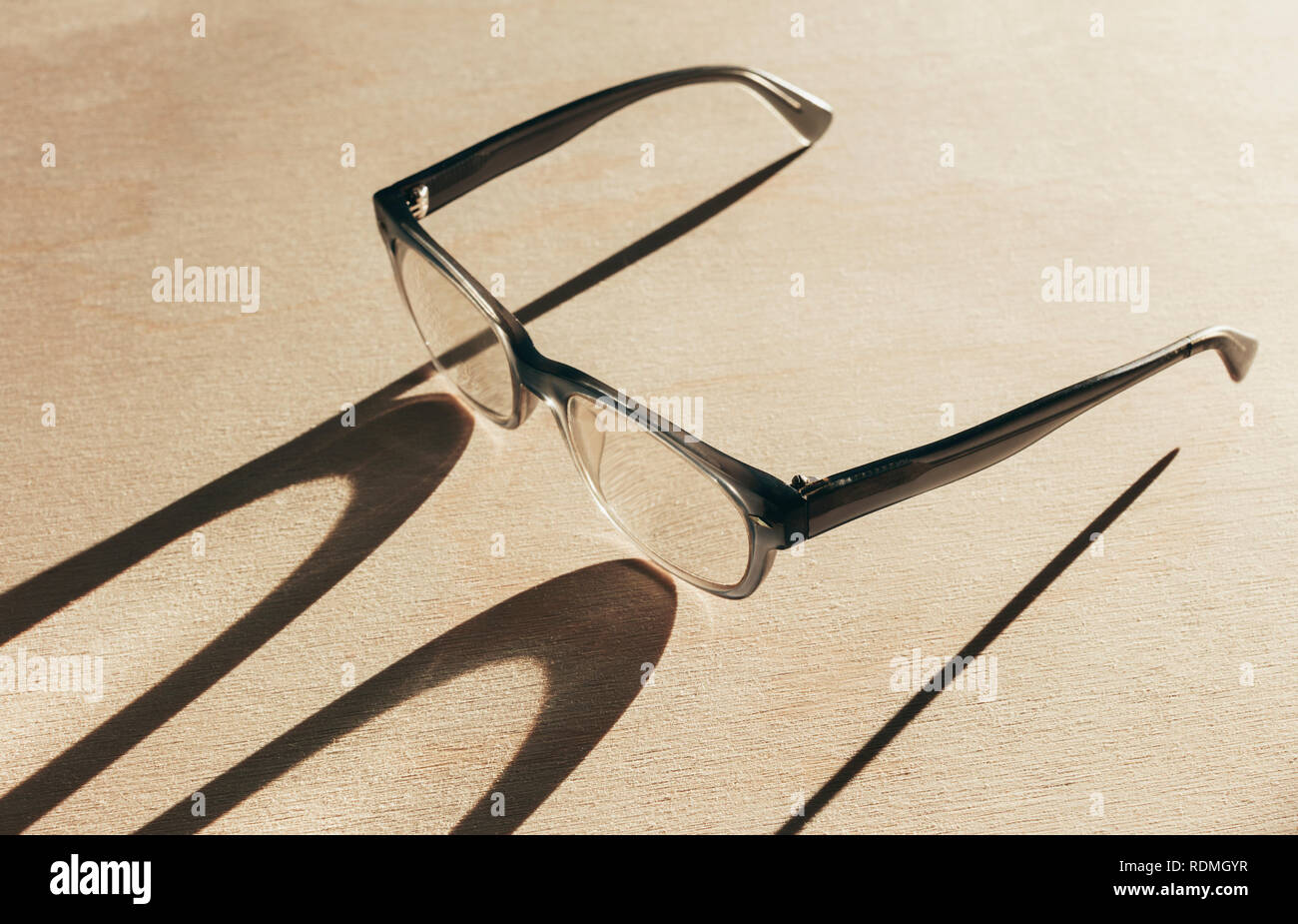 Close up de lunettes de lecture casting long shadow Banque D'Images