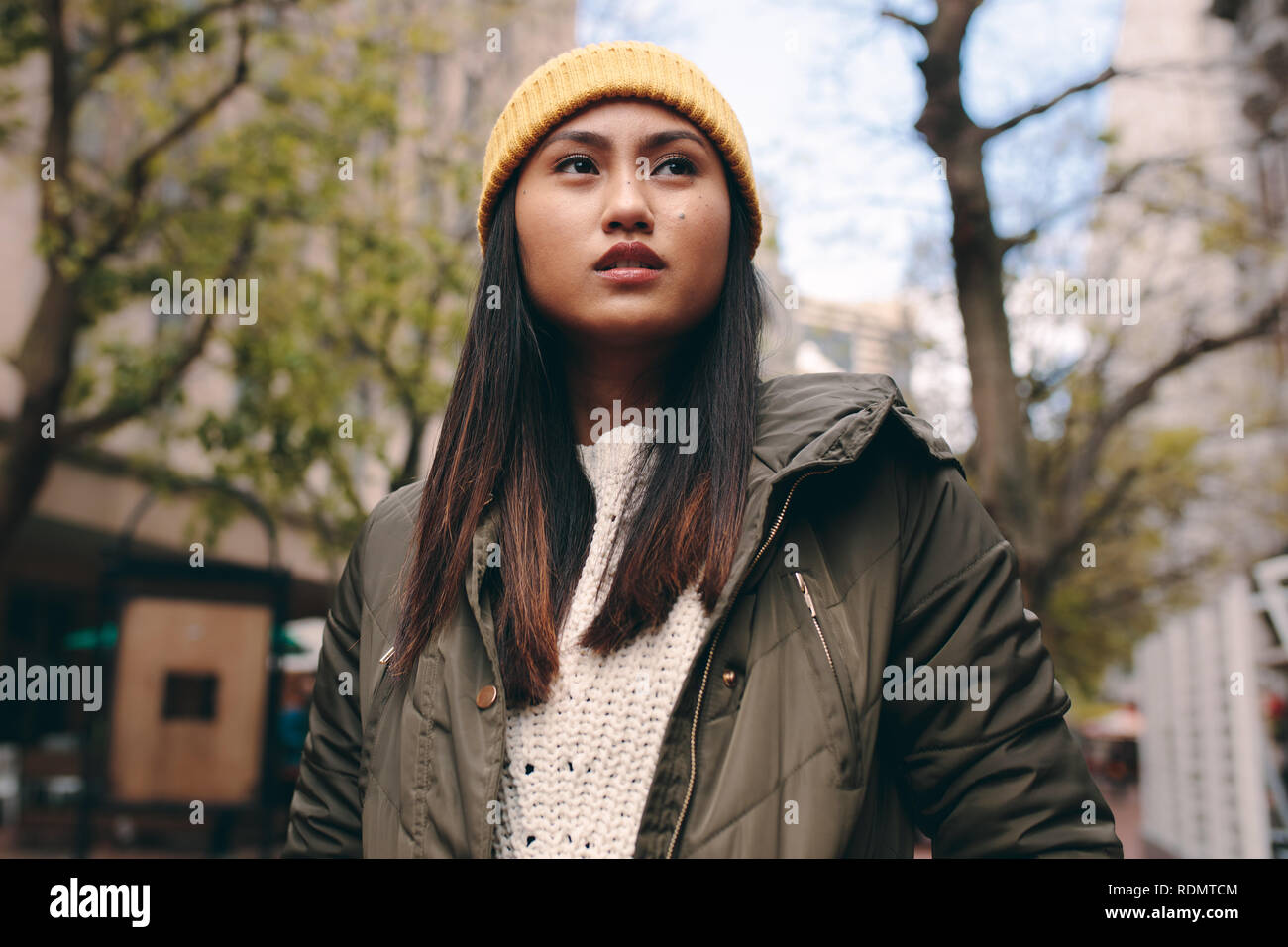 Close up of a woman in winter clothes comité permanent à l'extérieur. Asian woman standing dans la rue portant un chapeau d'hiver et à la voiture. Banque D'Images