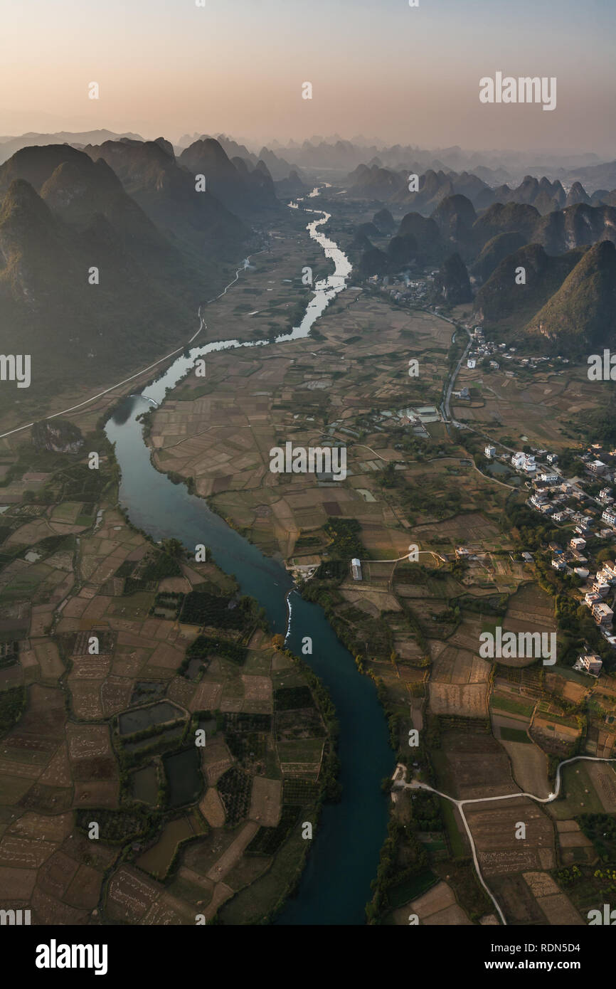 Vue aérienne de la rivière des Perles et de la route sinueuse en Chine sur des kilomètres le long de la vallée s'alimentant les champs de riz avec de l'eau. Banque D'Images