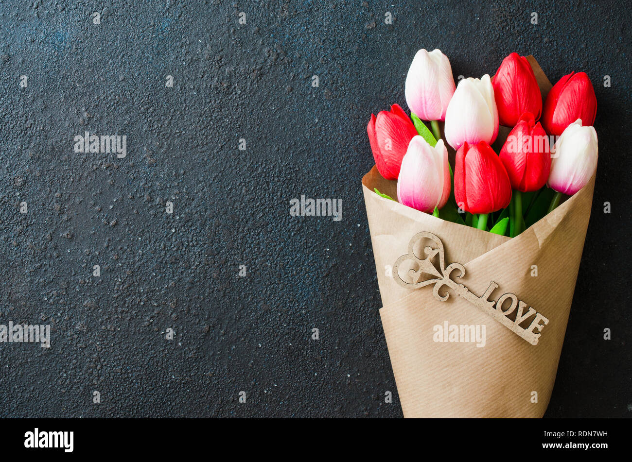 Maison de fond avec les fleurs du printemps. Bouquet de tulipes et touche décorative sur fond sombre. Carte de vœux pour la Saint Valentin, des femmes ou de la mère da Banque D'Images