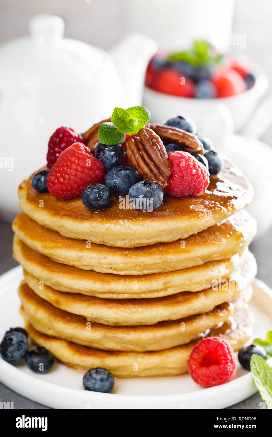 Pile de crêpes moelleuses avec les baies fraîches et noix de pécan Banque D'Images