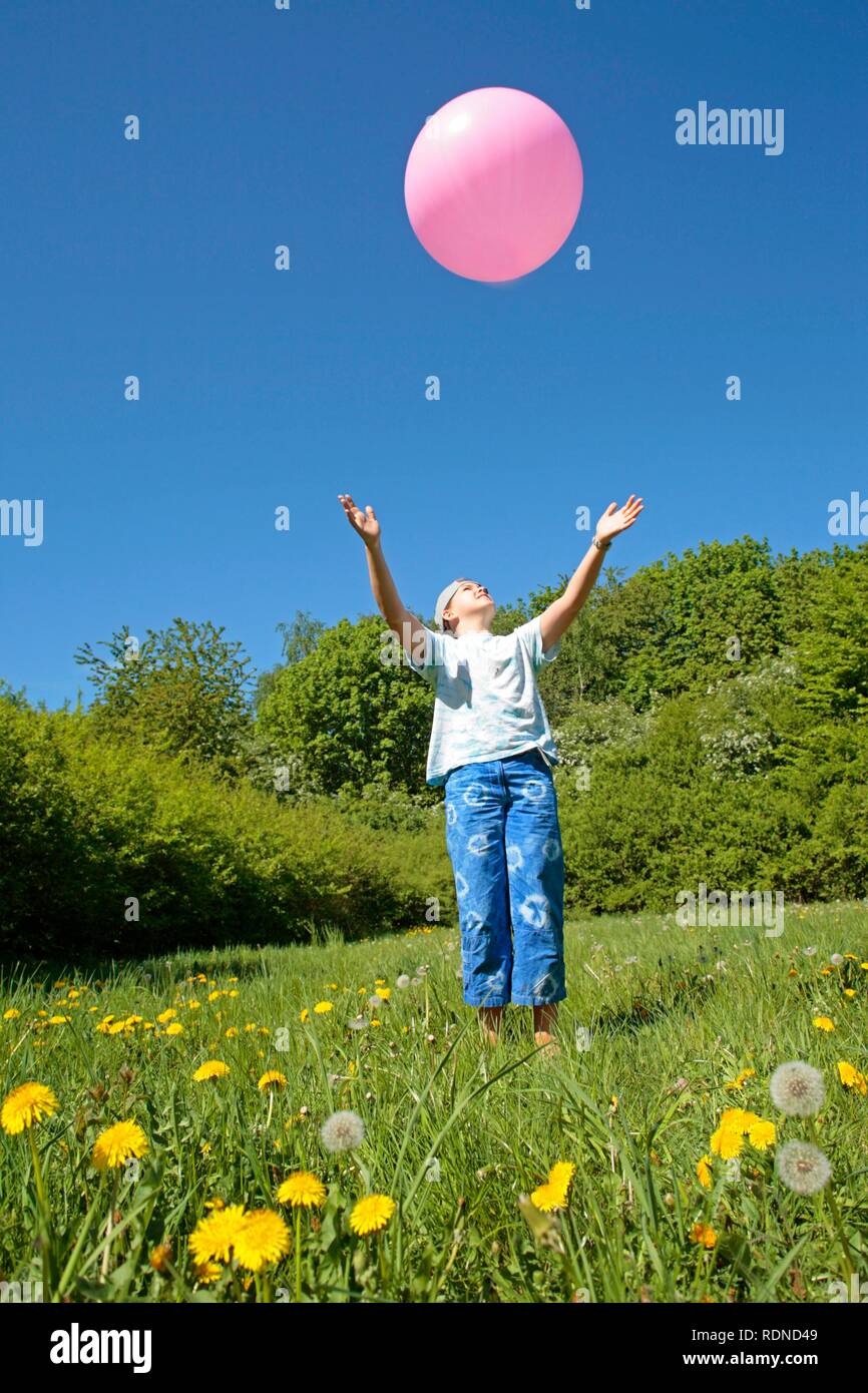 Fille essayant d'attraper un gros ballon rose Photo Stock - Alamy