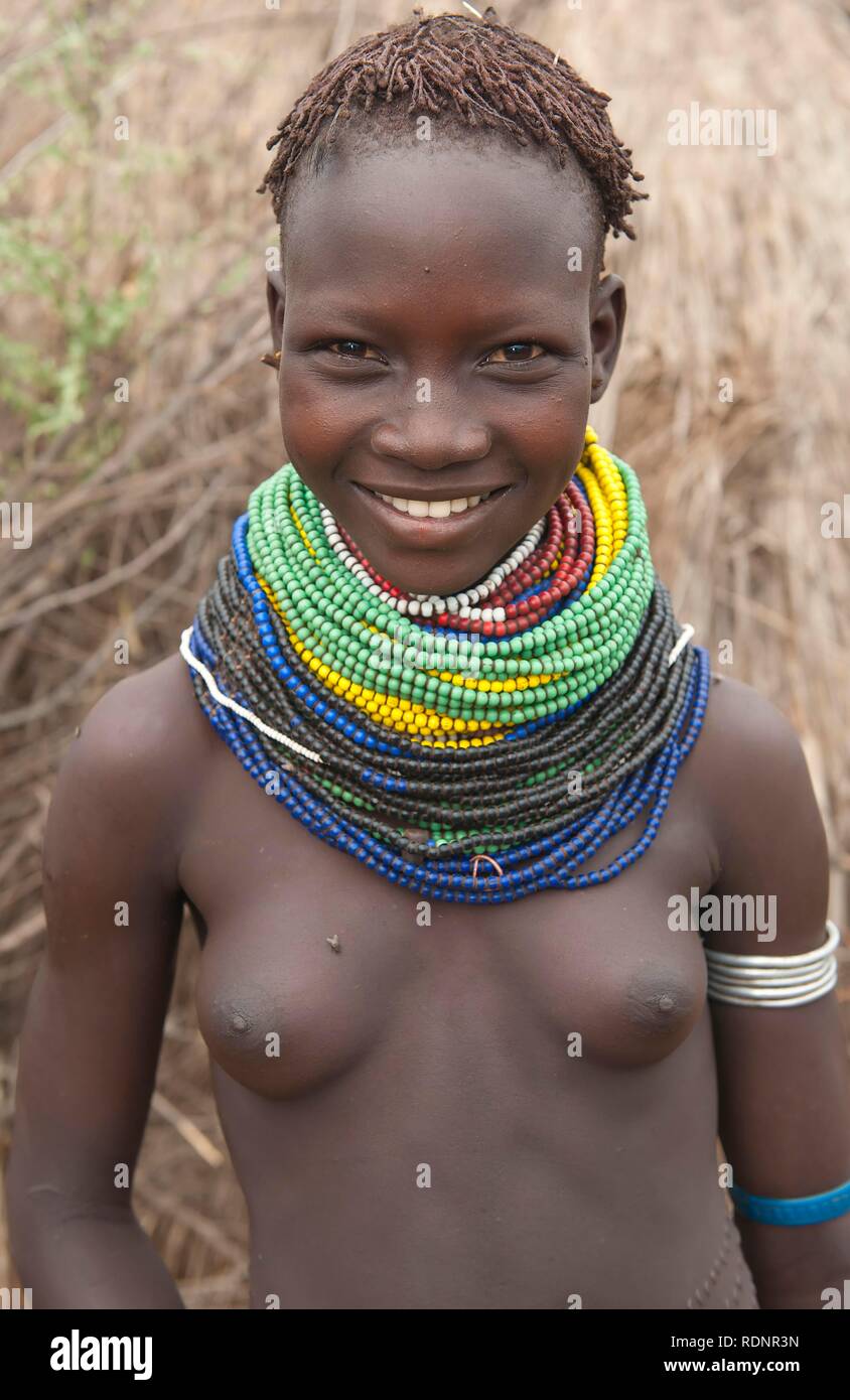 Les Nyangatom, Bume ou Buma fille avec colliers de perles devant sa hutte, vallée de l'Omo, Ethiopie, Afrique Banque D'Images