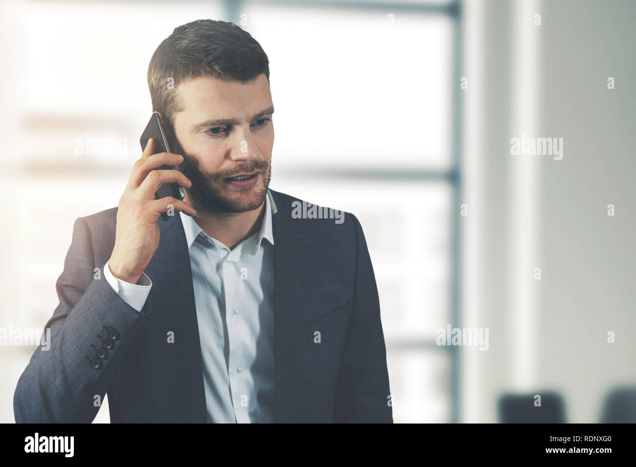 Business Communication - young businessman talking on the phone in office Banque D'Images