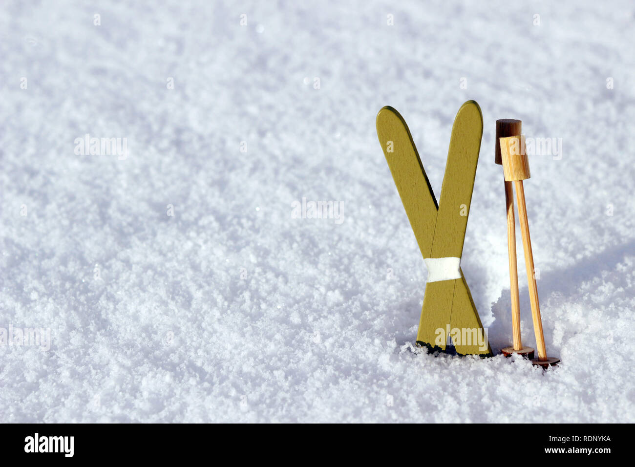 Paire de skis miniature avec des bâtons de ski debout dans la neige sur une journée ensoleillée Banque D'Images