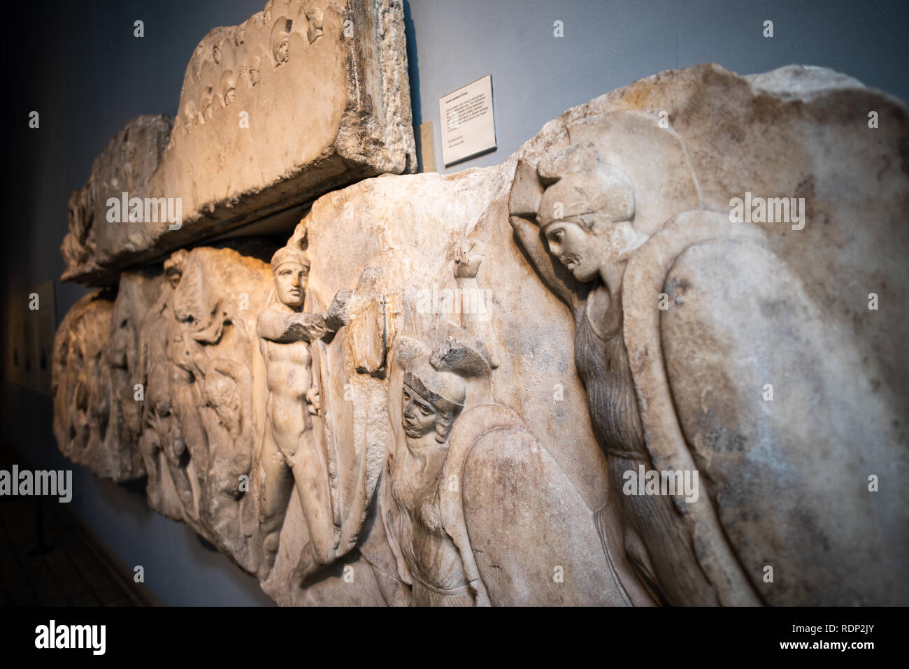 Nereid Monument Frieze British Museum Londres // LONDRES, Angleterre — Une vue détaillée d'un panneau en relief sculpté de la frise inférieure du podium du Monument Nereid, montrant des figures humaines dans les détails élaborés. Le monument, datant d'environ 390-380 av. J.-C., est considéré comme le plus grand et le plus beau des tombes lykiens découverts près de Xanthos dans le sud-ouest de la Turquie. Nommé d'après les Néréides - filles du Dieu de la mer Nereus - dont les figures apparaissent entre les colonnes du monument, ce trésor archéologique important représente l'architecture funéraire lykienne. Le British Museum a acquis le monument dans le Banque D'Images