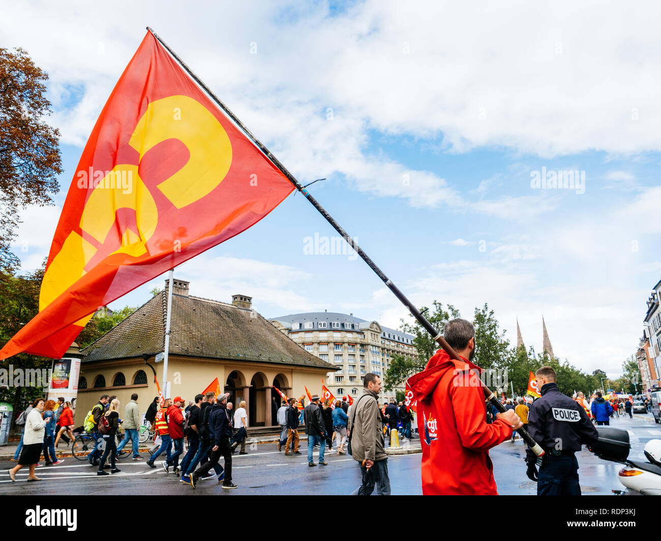 STRASBOURG, FRANCE - Sep 12, 2018 : rue centrale avec l'homme en agitant le drapeau de la CGT sur l'ensemble du territoire français de la rue au cours d'une journée de protestation contre la réforme du travail proposé par Emmanuel Macron Gouvernement avec agent de police surveiller la manifestation Banque D'Images