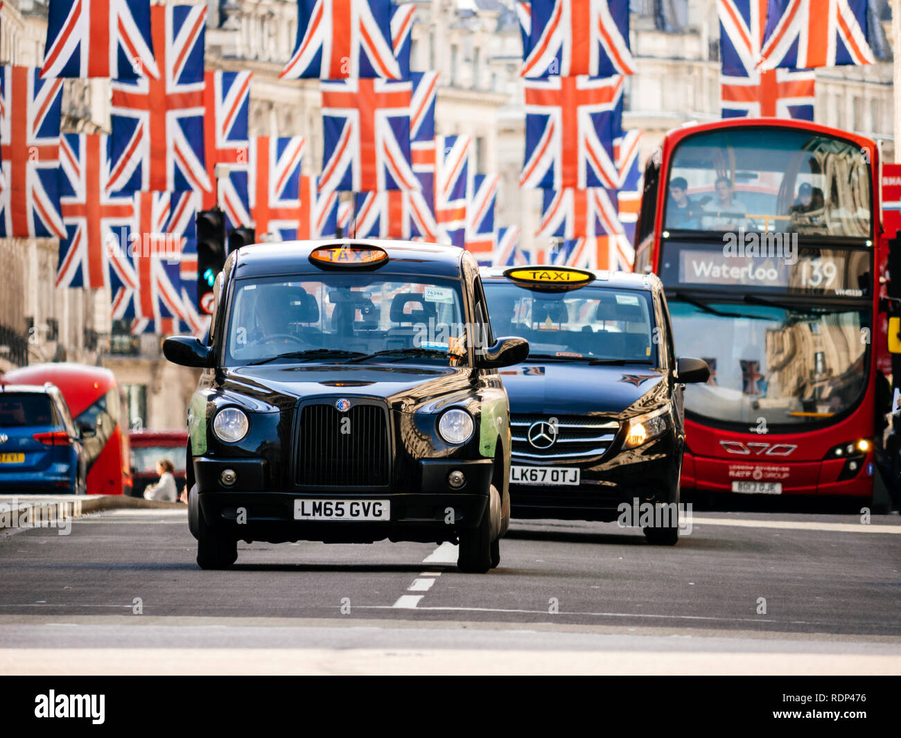 Londres, Royaume-Uni - 18 MAI 2018 : Des taxis et autobus en vertu de l'Union Jack drapeaux sur Regent Street, un jour avant le mariage royal. Le mariage royal entre le Prince Harry et Meghan Markle aura lieu au Château de Windsor dans le Berkshire le 19 mai 2018. Banque D'Images