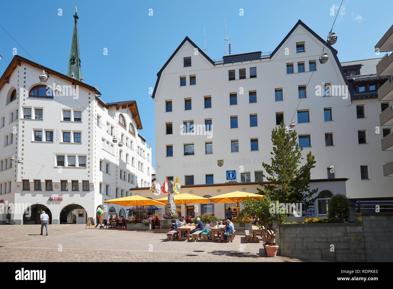 SANKT MORITZ, Suisse - le 16 août 2018 : Centre Ville avec trottoir tables, parasols jaunes et des personnes dans un jour d'été ensoleillé à Sankt Moritz, Suisse Banque D'Images