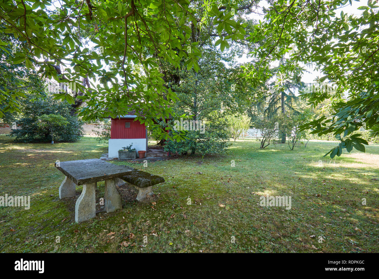 Table et bancs en pierre avec jardin et châtaigniers dans une journée ensoleillée, Italie Banque D'Images