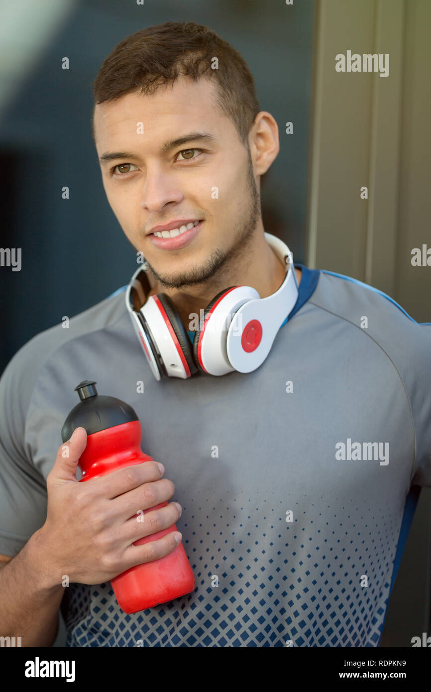 Jeune homme latin bouteille eau smiling runner format portrait sports outdoor fitness formation en cours d'exécution Banque D'Images
