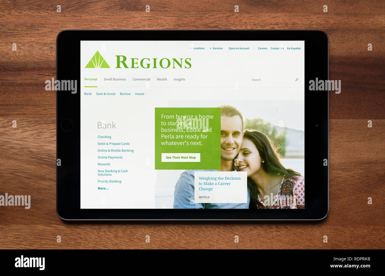 Le site web de la Société financière des régions est vu sur un iPad tablet, qui repose sur une table en bois (usage éditorial uniquement). Banque D'Images