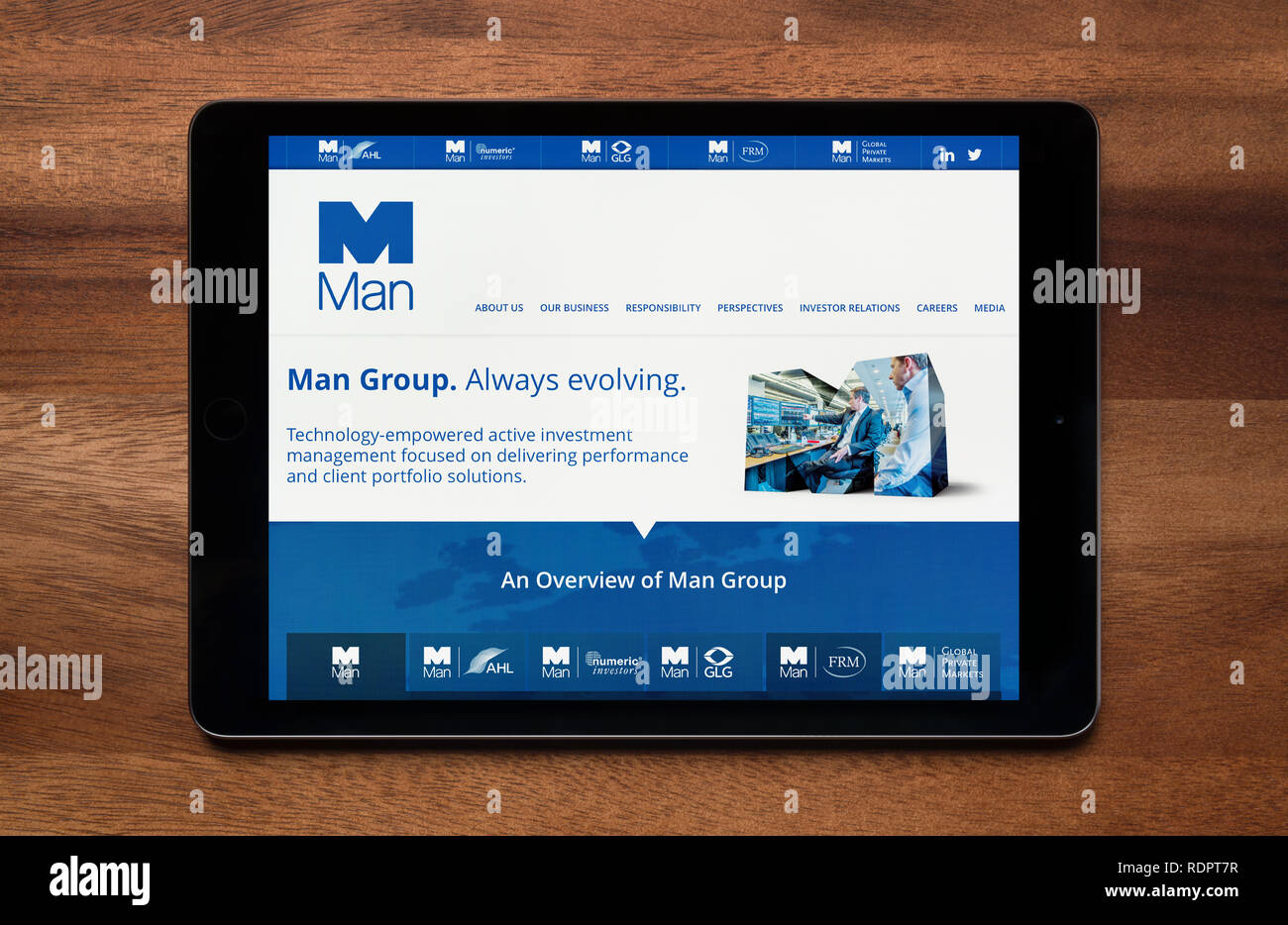 Le site internet de Man Group est considéré sur une tablette iPad, qui repose sur une table en bois (usage éditorial uniquement). Banque D'Images