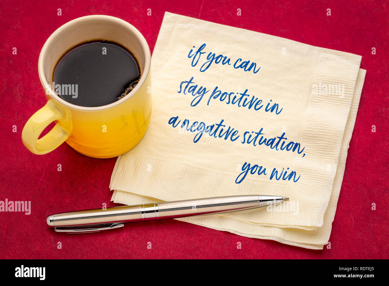 Si vous pouvez rester positif dans une situation négative, vous gagnez de l'écriture- sur une serviette avec une tasse de café Banque D'Images
