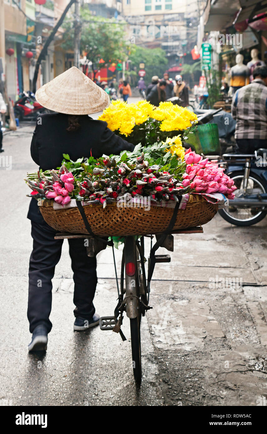 Femme vente de fleurs dans la rue à Hanoi, Vietnam Banque D'Images