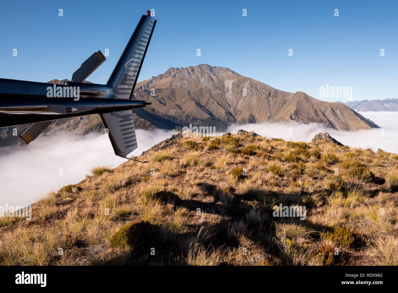 Sur scène en milieu de matinée d'une montagne près du Mont Creighton couvertes de nuages au-dessus du lac Wakatipu près de Queenstown sur l'île du sud de Nouvelle-Zélande. Banque D'Images Sur scène en milieu de matinée d'une montagne près du Mont Creighton couvertes de nuages au-dessus du lac Wakatipu près de Queenstown sur l'île du sud de Nouvelle-Zélande. Banque D'Images